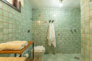 a bathroom with a toilet and a shower with blue tiles at Jardim da Amazônia Lodge in Sao Jose do Rio Claro +174 photos