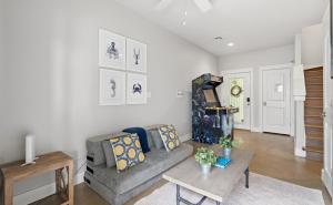 a living room with a couch and a table at Tranquil Turtle complete with Arcade plus Pool optional Golf Cart in Port Aransas