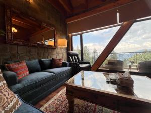 a living room with a couch and a table at Alpine Home By HespakBNB in Dunga Gali