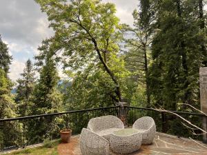 a couple of chairs sitting on top of a balcony at Alpine Home By HespakBNB in Dunga Gali