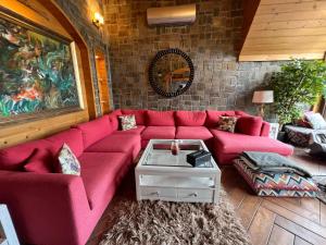 a living room with a red couch and a table at Alpine Home By HespakBNB in Dunga Gali +20 photos