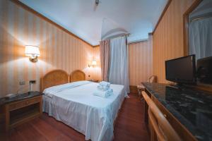 a hotel room with a bed and a flat screen tv at Hotel Miro' in Rapallo