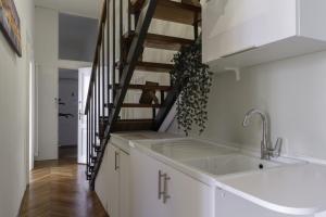 a kitchen with white cabinets and a spiral staircase at TONIOLO VENICE ROOMS in Mestre +88 photos