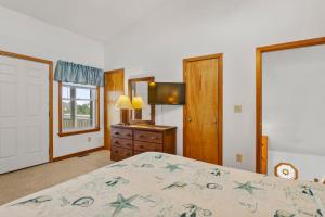 a bedroom with a bed and a television and a window at HISA14: Sunny Daze in Salvo