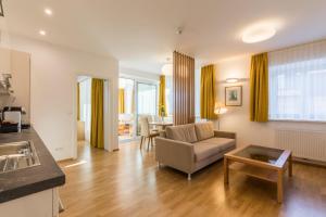ein Wohnzimmer mit einem Sofa und einem Tisch in der Unterkunft Vienna Grand Apartments City in Wien