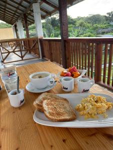 a table with a plate of breakfast food and coffee at Dani's Guesthouse in Las Galeras