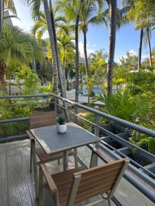 a table and chairs on a balcony with palm trees at Résidence Adam et Eve in Orient Bay