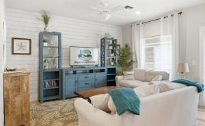 a living room with a couch and a table at Tranquil Turtle complete with Arcade plus Pool optional Golf Cart in Port Aransas