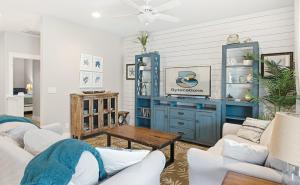 a living room with blue cabinets and a table at Tranquil Turtle complete with Arcade plus Pool optional Golf Cart in Port Aransas