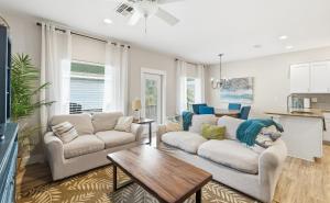 a living room with two couches and a table at Tranquil Turtle complete with Arcade plus Pool optional Golf Cart in Port Aransas +27 photos