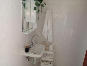 a white bathroom with a sink and a mirror at on the STRIP apartment 4 in Kavos +35 photos