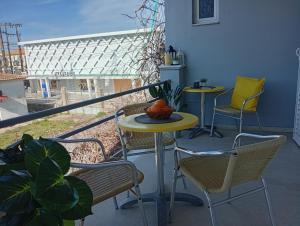 two tables and chairs on a balcony with a view at on the STRIP apartment 4 in Kavos