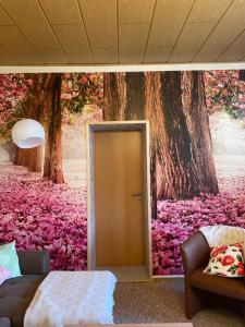 a bedroom with a tree and a door with pink flowers at Fewo an der Stadtmauer in Quedlinburg