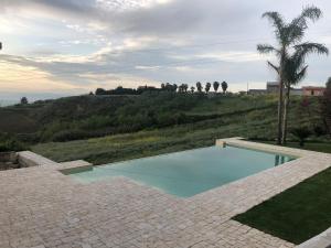 a swimming pool in the middle of a brick patio at RossoScirì in Calatafimi