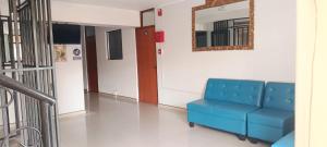 a blue couch in a hallway with a mirror at Hotel Diamante Azul in Huancayo +14 photos