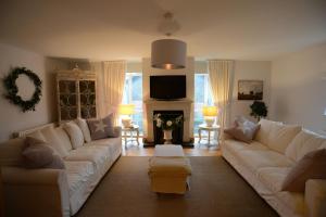 a living room with a white couch and a fireplace at Beech House in Antrim +15 photos