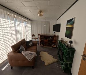 a living room with a couch and a television at FeWo zum Der Hilderser in Hilders