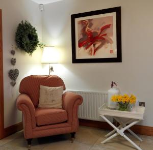 a living room with a chair and a side table at Beech House in Antrim