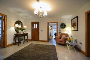 a living room with a couch and a chair and a table at Beech House in Antrim