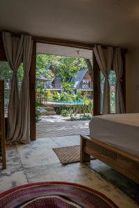 a bedroom with a bed and a view of a yard at Sambe Manglar in Moñitos
