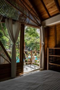 a bedroom with a bed and a large window at Sambe Manglar in Moñitos
