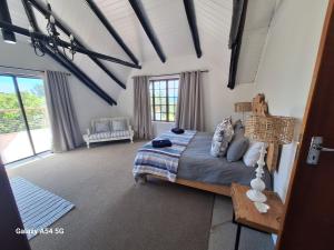 a bedroom with a bed and a large window at The White House @ Cintsa in Chintsa
