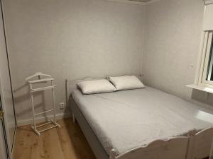 a small bedroom with a bed and a night stand at Kukkolaforsen 160 in Haparanda