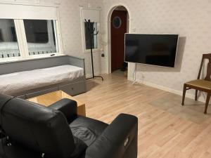a living room with a couch and a flat screen tv at Kukkolaforsen 160 in Haparanda