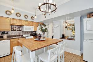 a kitchen with a wooden table and white appliances at Haint & Porcelain in Savannah