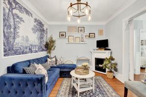 a living room with a blue couch and a chandelier at Haint & Porcelain in Savannah