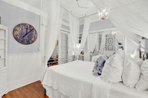 a bedroom with a bed with a clock on the wall at Haint & Porcelain in Savannah +21 photos