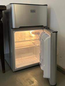 an empty refrigerator with its door open in a room at Lezama Suites in Buenos Aires