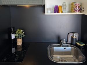 a sink in a kitchen with a black counter top at Studio proche Calvi in Lumio +30 photos