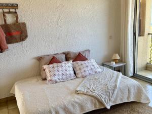 a bed with pillows on it in a bedroom at Studio proche Calvi in Lumio