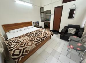 a bedroom with a bed and a couch and a chair at The Quiet corner 1RK Downtown in Guwahati