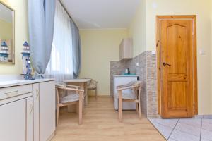 a kitchen with a table and chairs and a door at Willa Irena in Karwia