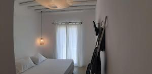a bedroom with a white bed and a window at Maria's Private Space - Mykonos in Ano Mera