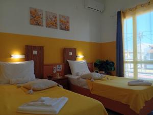 two beds in a room with yellow walls at on the STRIP-Studio 1 in Kavos