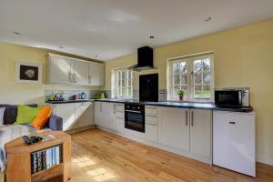 a kitchen with white cabinets and a couch at 1 Bed in Northrepps oc-1736 in Northrepps +7 photos
