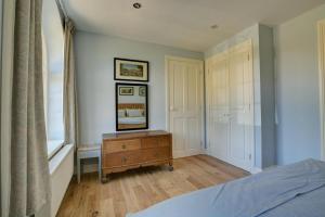 a bedroom with a bed and a dresser and a window at 1 Bed in Northrepps oc-1736 in Northrepps