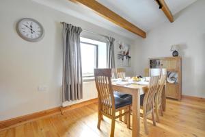 a dining room with a table and chairs and a clock at 2 Bed in Cowling oc-ds238 in Cowling