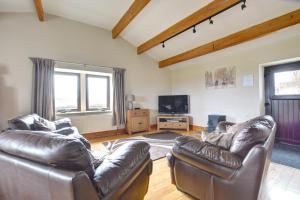 a living room with two leather couches and a tv at 2 Bed in Cowling oc-ds238 in Cowling