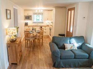 a living room with a blue couch and a kitchen at 2 Bed in Launceston oc-41992 in Saint Giles on the Heath