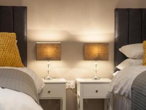 two nightstands with lamps on them next to two beds at 2 Bed in Launceston oc-41992 in Saint Giles on the Heath