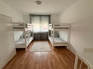 a room with three bunk beds and a wooden floor at Ferienwohnungen Uhrturm in Oppenheim