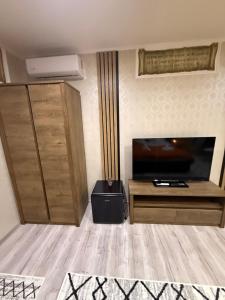 ein Zimmer mit Flachbildfernseher und Holzschränken in der Unterkunft Sofhia home in Târgu Mureș