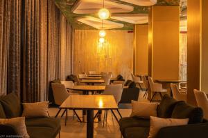 a restaurant with couches and tables and chairs at Atrium Hotel in Vulcan