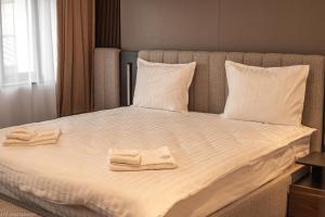 a bed with two towels on top of it at Atrium Hotel in Vulcan +8 photos