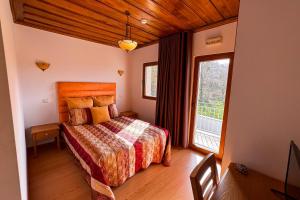 a bedroom with a bed and a large window at Casa do Olival in Macedo de Cavaleiros