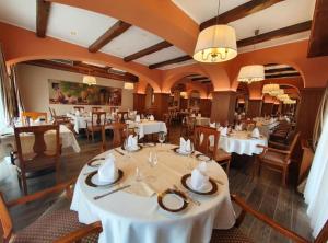 a dining room with white tables and chairs at Jurjevec Castle in Brežane Lekeničke